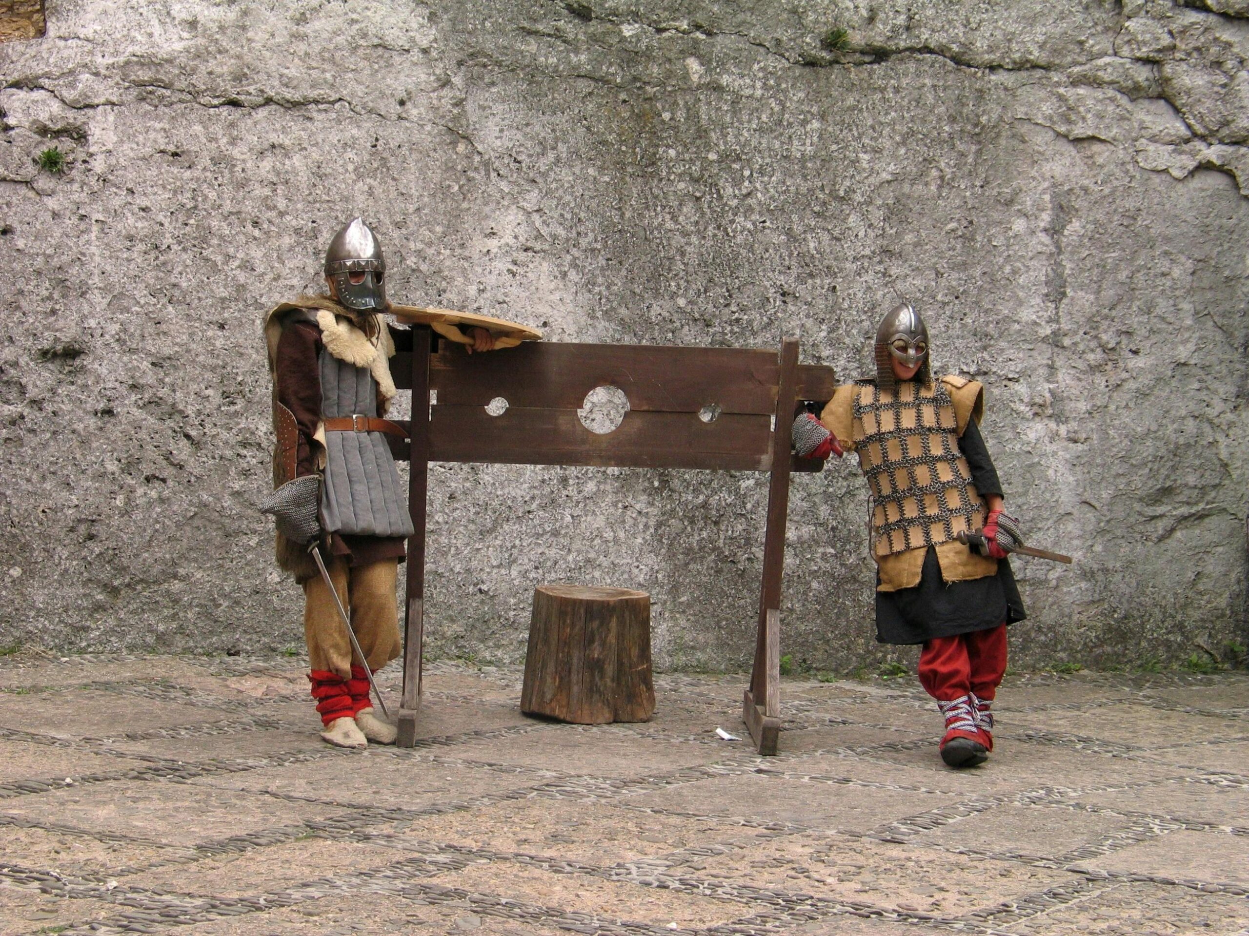 Photo of People Wearing Medieval Costumes, Posing with a Guillotine