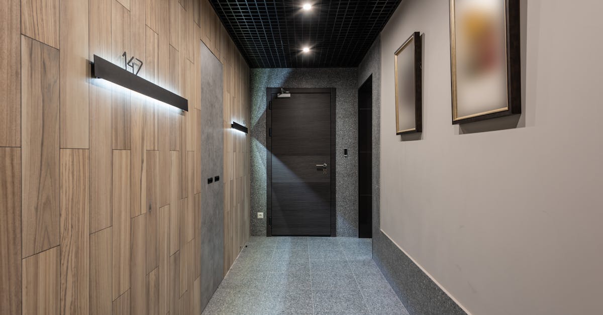 Interior of hallway with illuminated numbers of hotel rooms hanging on wall near doors