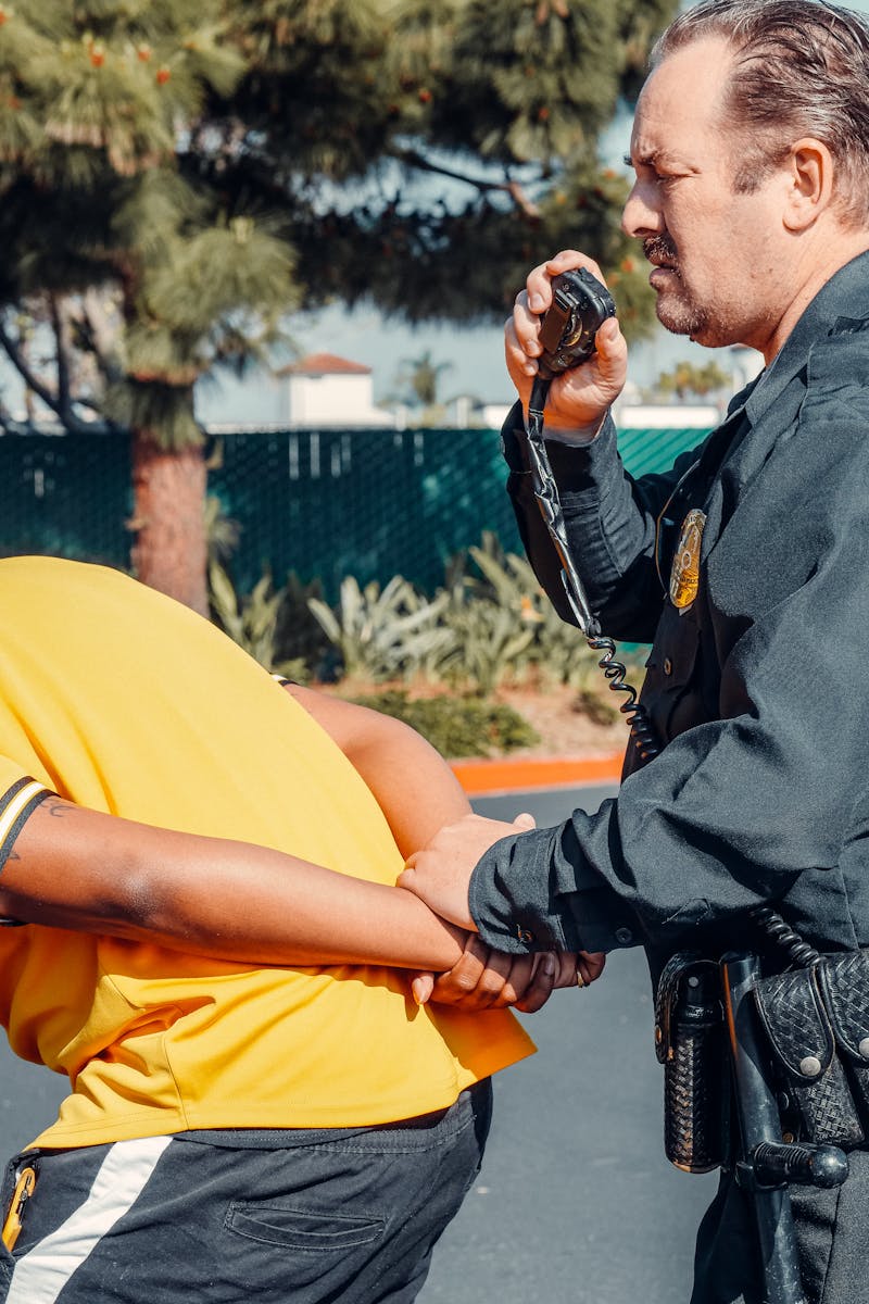 Police Officer Arresting a Man in Yellow Shirt