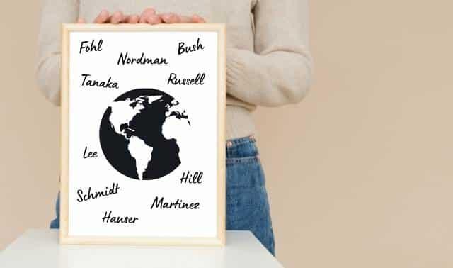 Woman holding board with an outline of the Earth and handwritten surnames