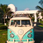 Classic vintage van parked on a sunny Anguilla driveway, surrounded by palm trees.